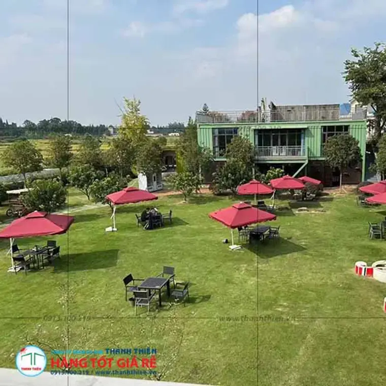 Ảnh drone khu cafe sân cỏ với 10–12 ô dù vuông đỏ đậm vải dù Hàn Quốc — dự án thực tế Thanh Thiên Furniture