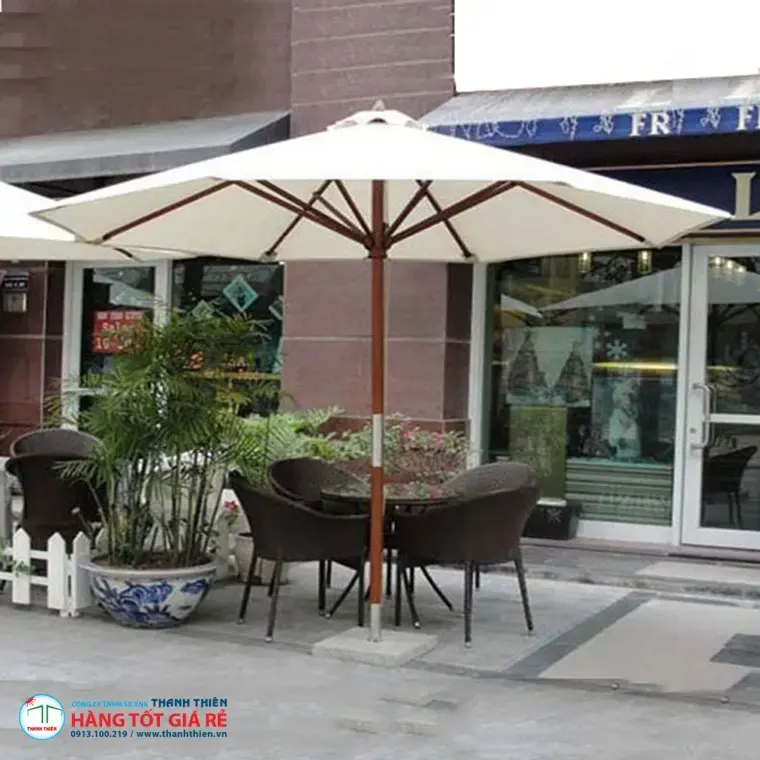 Ô dù chính tâm tròn trắng kem trên cột gỗ đặt vỉa hè quán cafe — vải dù ngoài trời cho nhà hàng đô thị