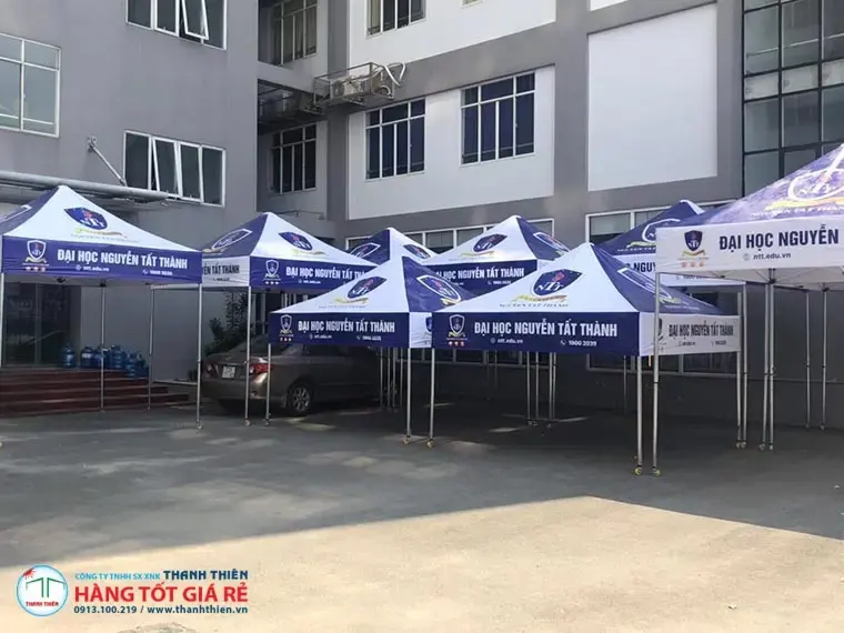 Nhiều lều xếp nhà bạt in logo Đại Học Nguyễn Tất Thành màu xanh tím